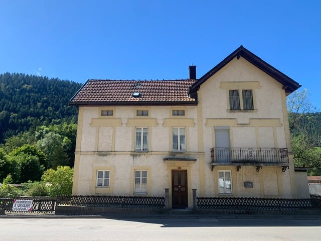 Traditional house, 3 stories, brown roof, yellow exterior, balcony, fenced