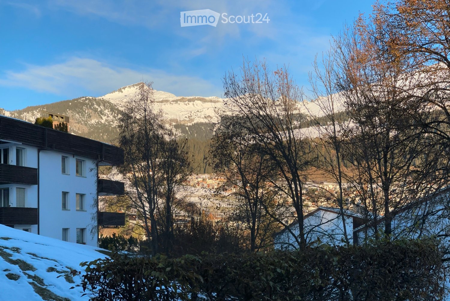 Multistory building with balconies, mountains in the background