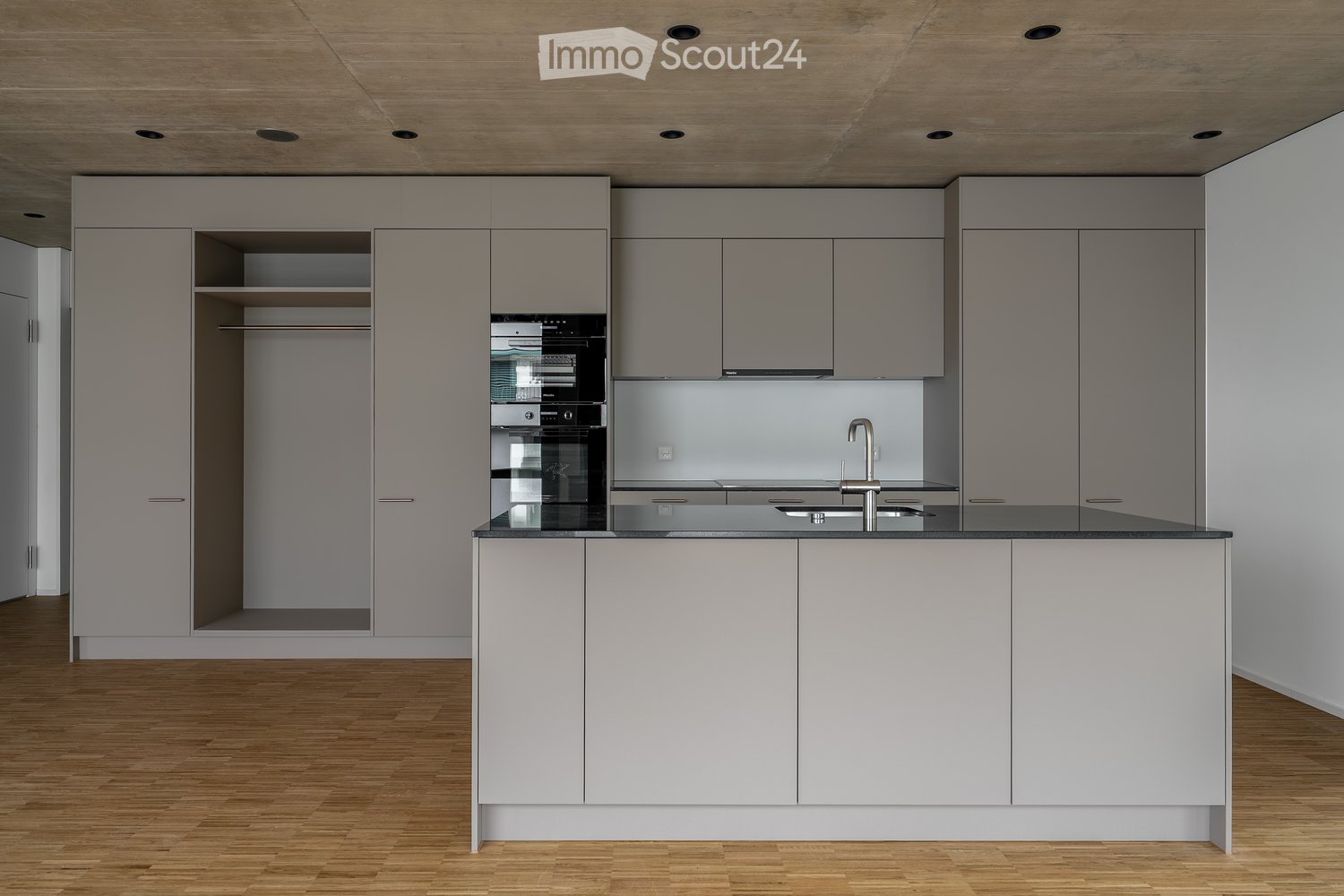 modern kitchen with built-in appliances, gray cabinets, wooden floors, center island