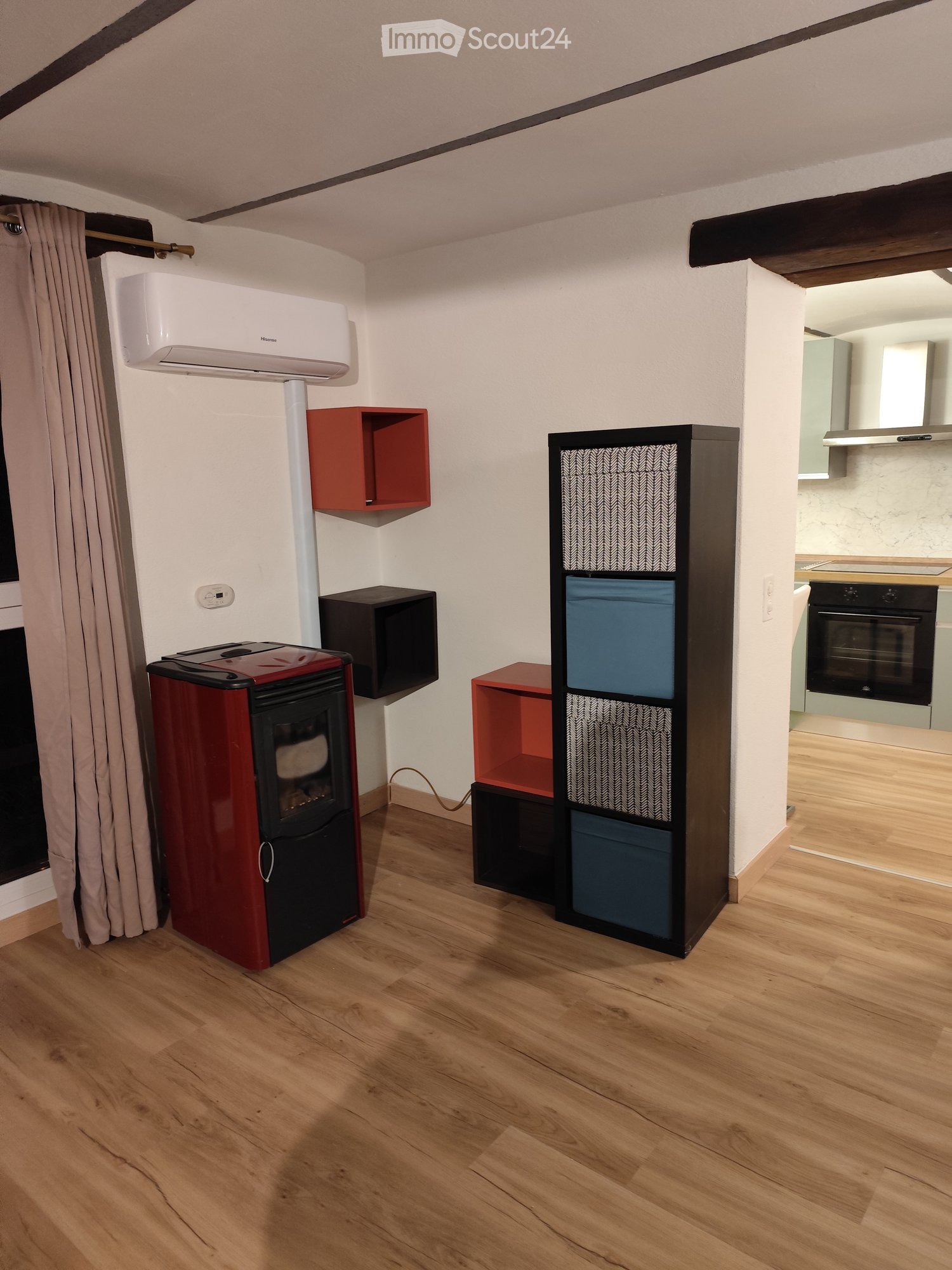 room with wood floor, fireplace, shelfs, air conditioner, wall mounted storage boxes, small red storage box, black storage box