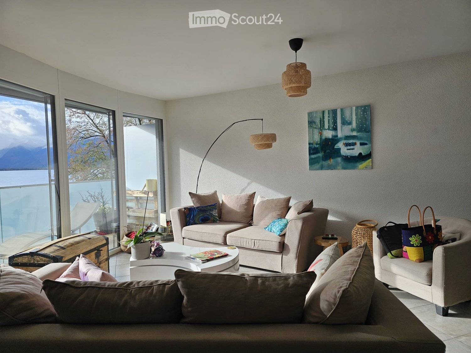 modern design, glass walls, large windows, balcony with outdoor furniture, decorative pillows, coffee table, floor lamp, painting on the wall, large sofa, comfortable armchair