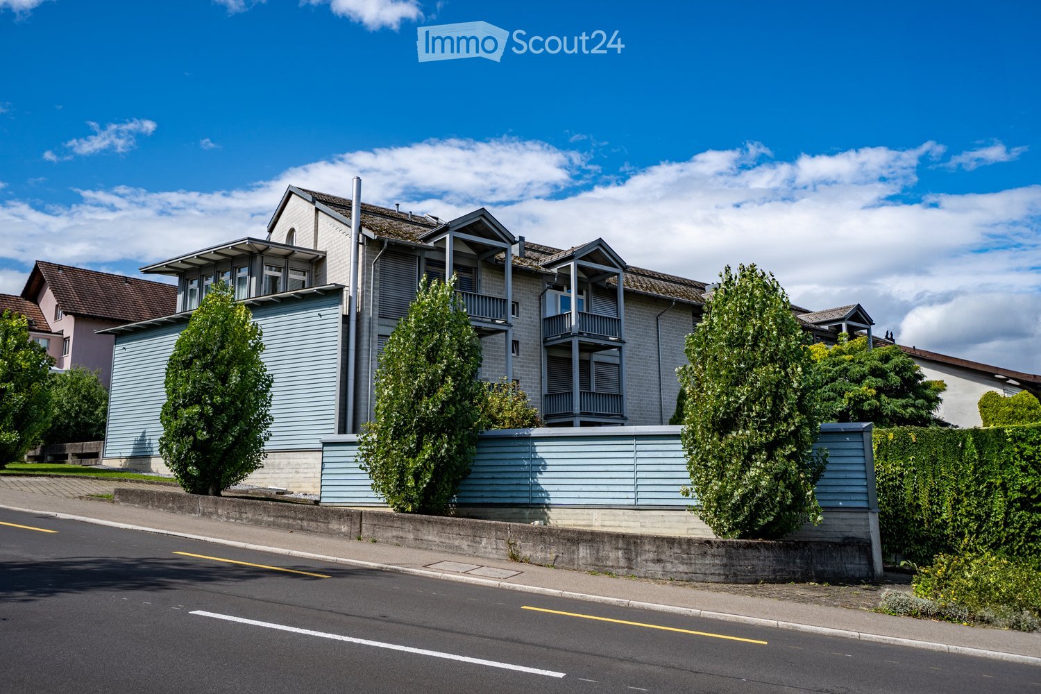 two story house, blue wall, green trees, front yard, balcony