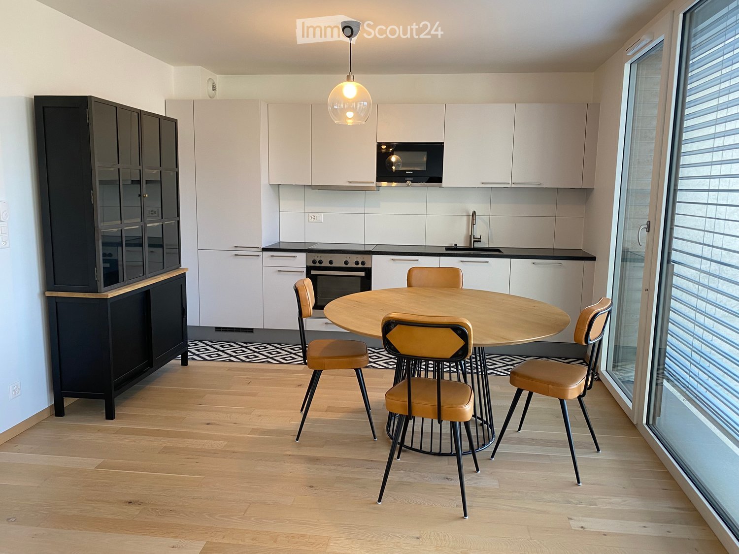 modern kitchen, wooden table and chairs, white cabinets, white tile flooring, black stove and microwave