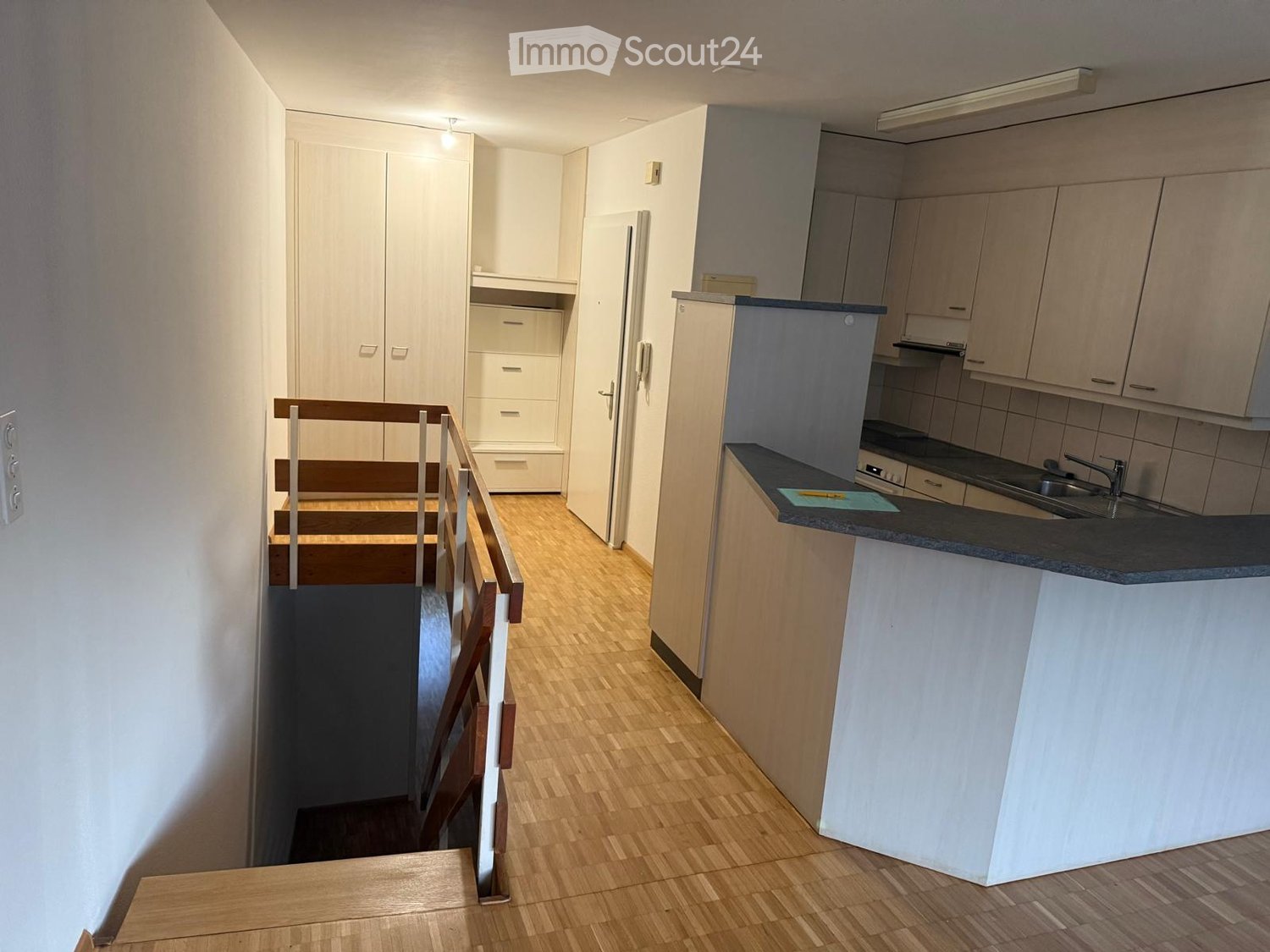 kitchen with sink, tiled floor, wooden staircase