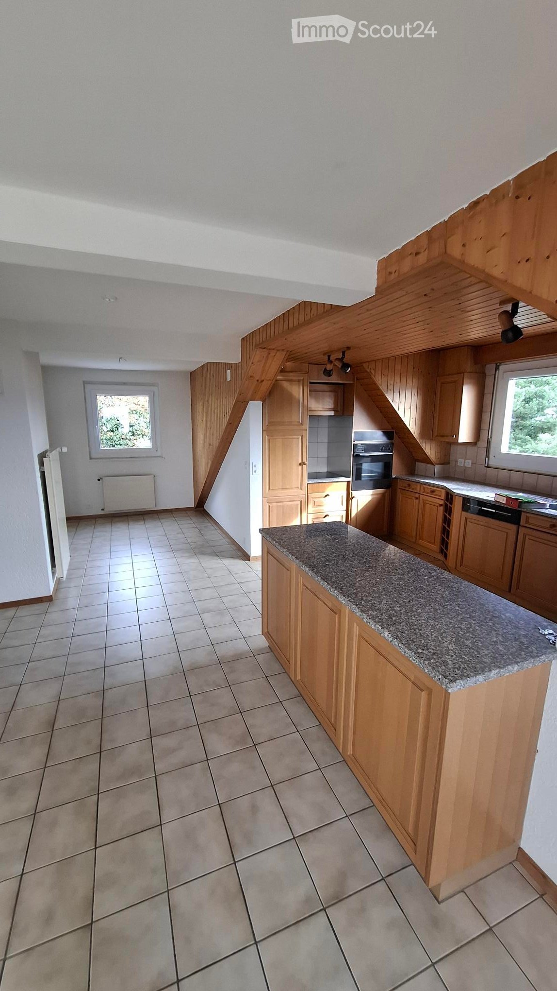 Empty kitchen with granite countertop, wooden cabinets, two windows, radiator, modern ceiling, oven