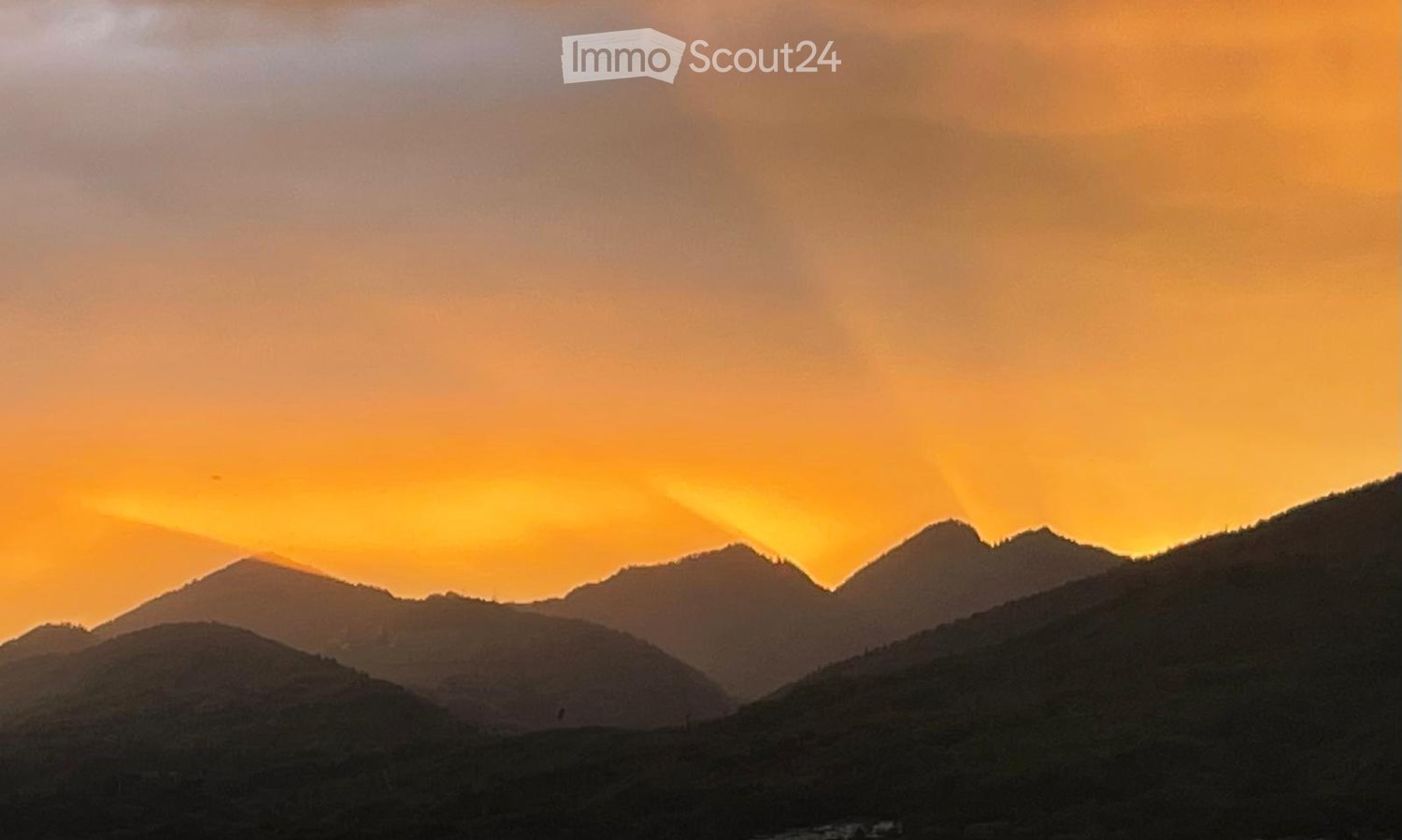 Mountain range with clouds and setting sun