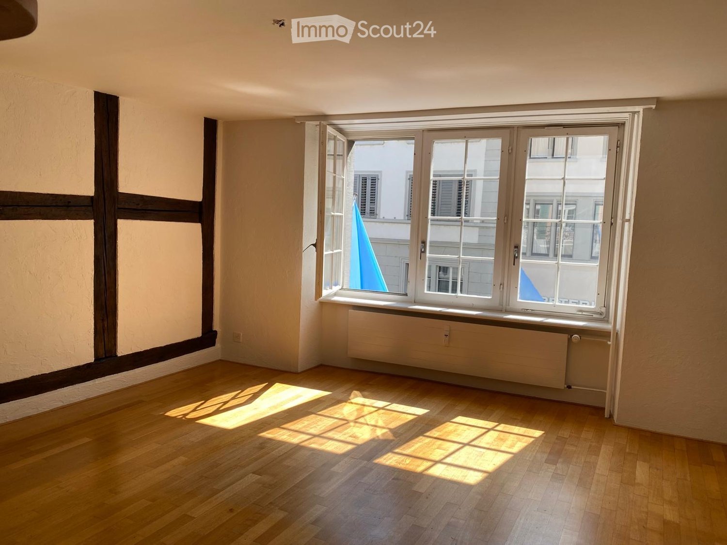 empty room, large windows, wooden floor, white walls, wooden framed walls