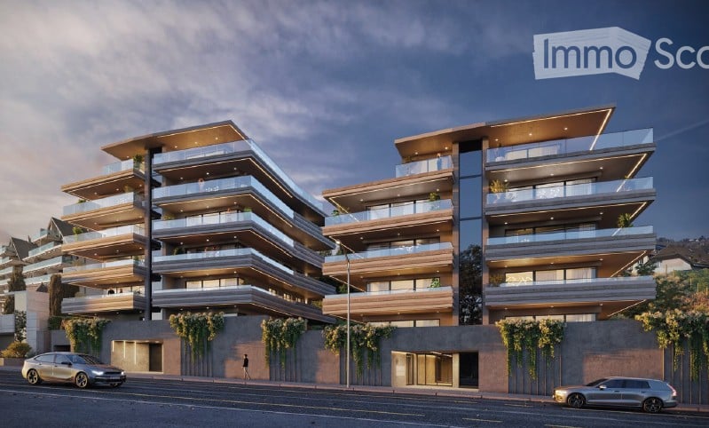 Multi-level apartment building with several terraces, glass railings, green plants on walls
