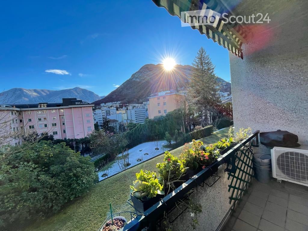 Terrace, plants, mountains in the background, and a city skyline in the background