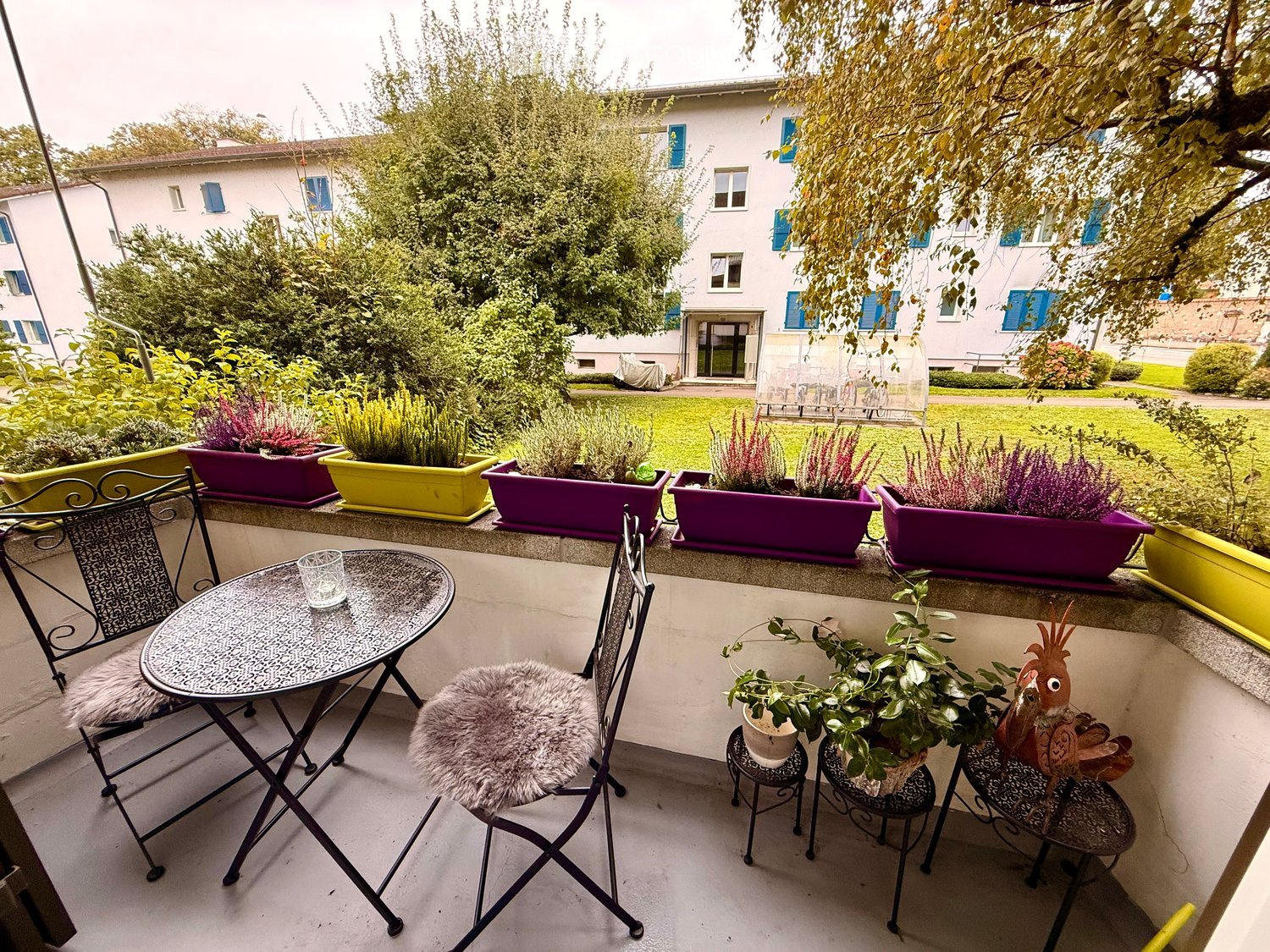 balcony with table, chairs, plants, trees, garden view