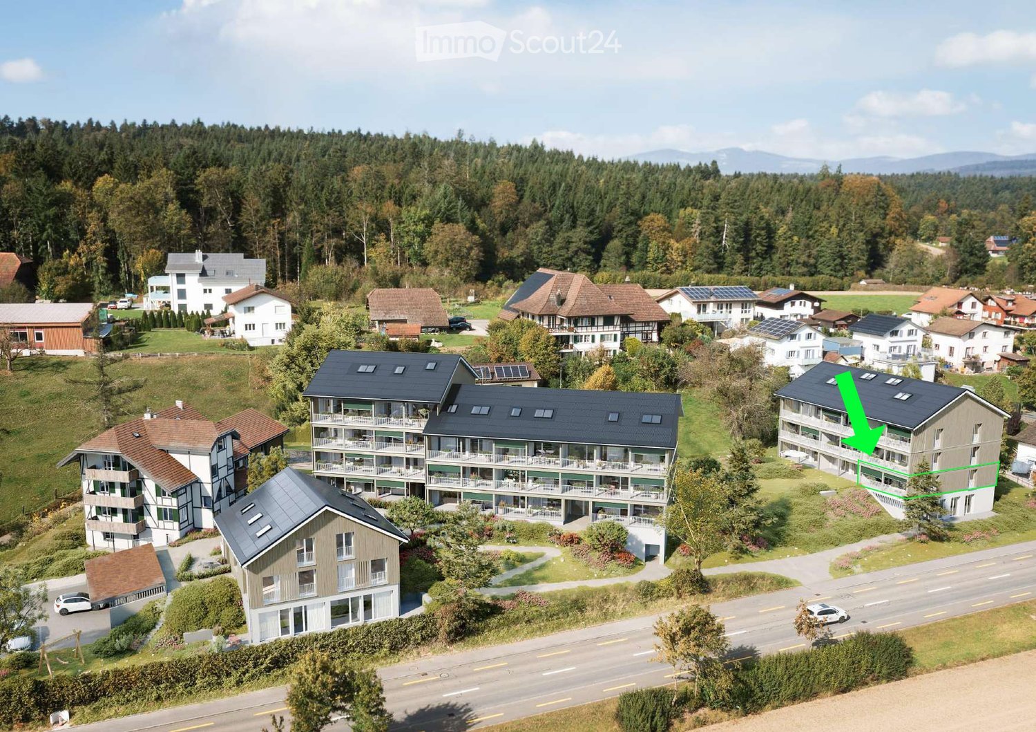 multiple residential buildings with solar panels on the roofs, balconies, and lush greenery, surrounded by trees and hills