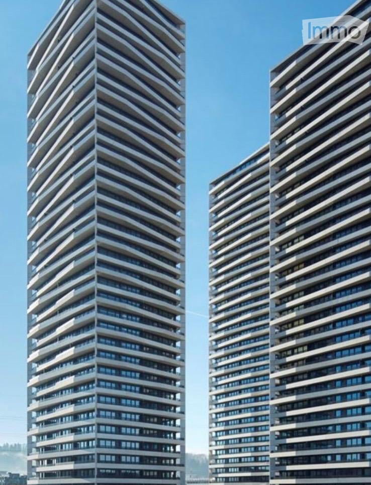 Modern multi-story towers with a sleek and angular design, balconies, and large windows