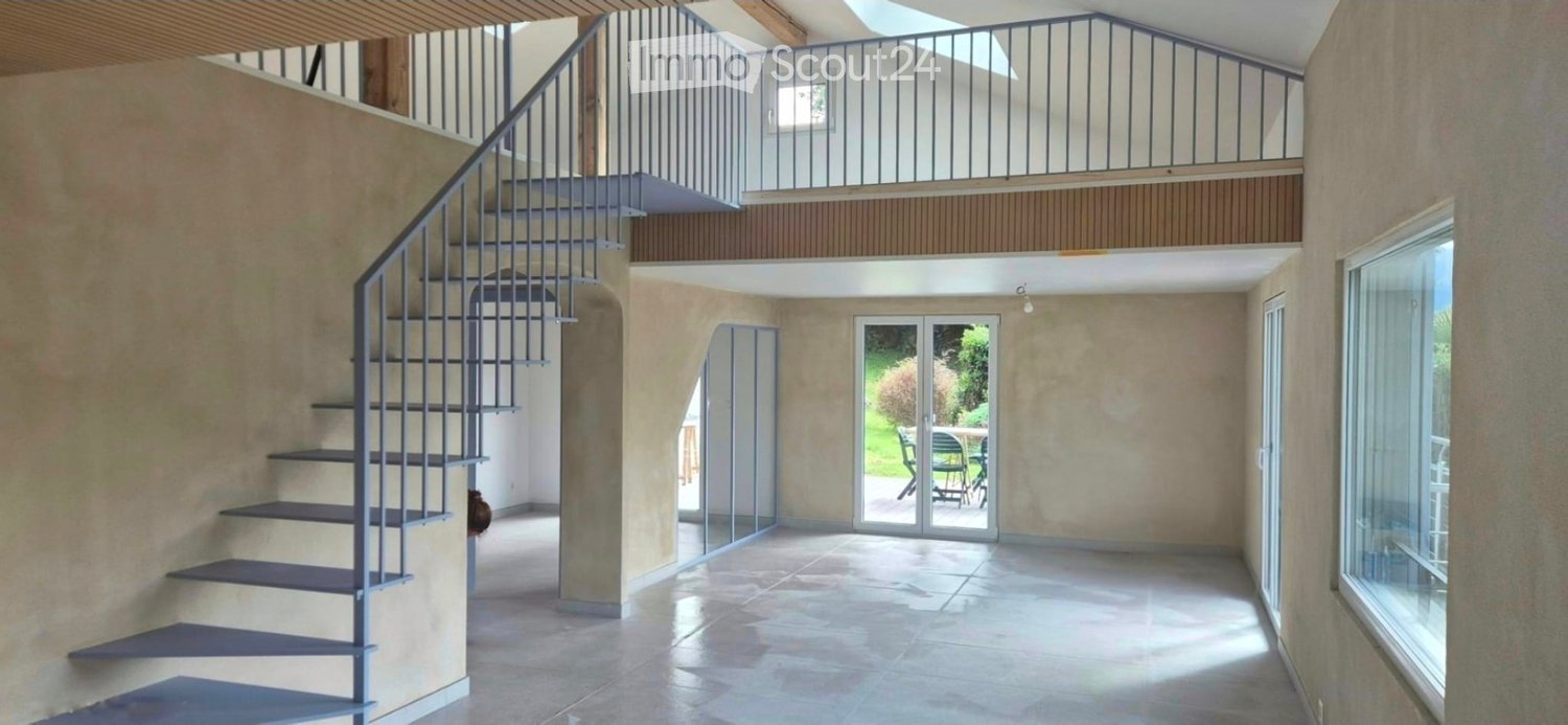 empty interior with tile floor, spiral staircase, glass doors leading to patio, large windows