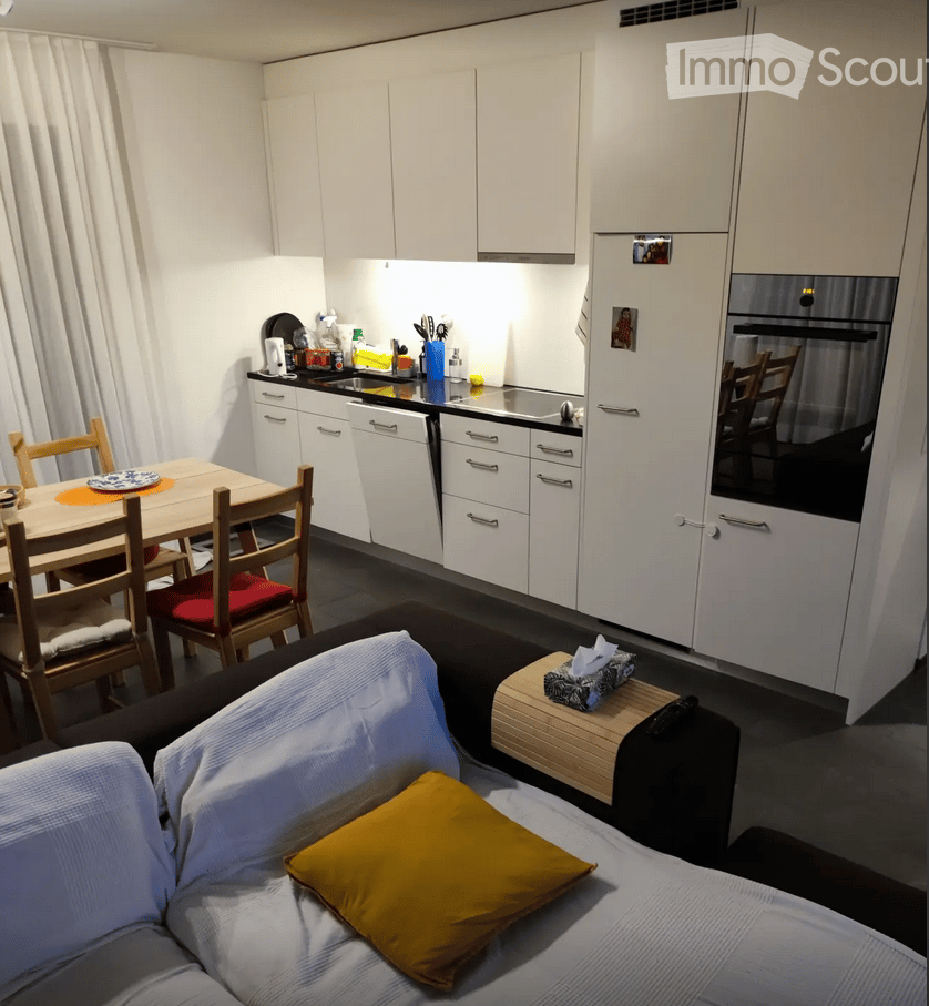 modern kitchen, wooden dining table, white cabinets, black countertops, white appliances, sink, faucet