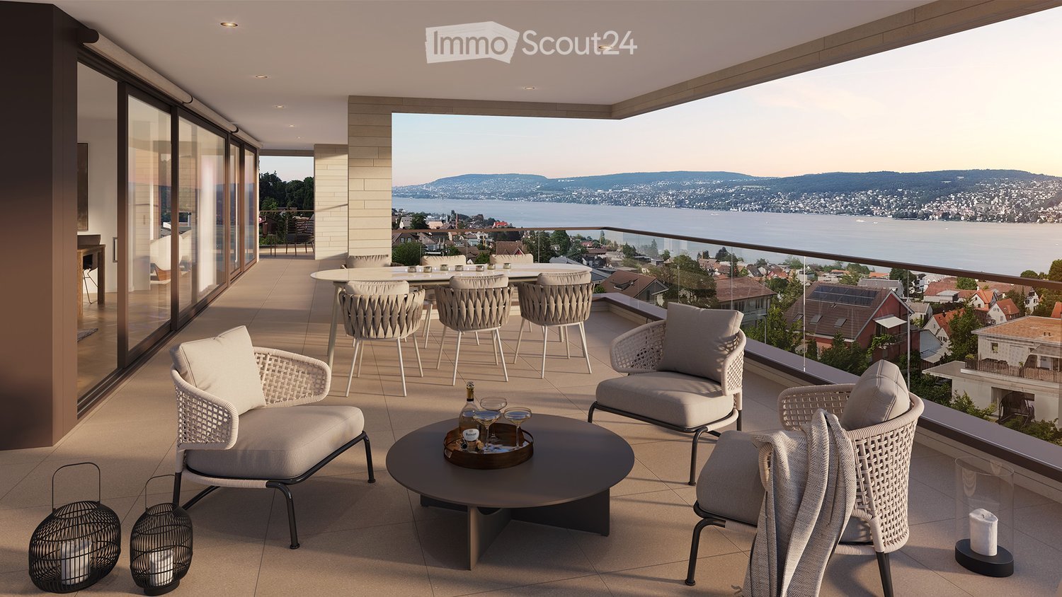 outdoor seating area, glass railing, lake view, wooden table, bottles of wine, chairs, cushions, lanterns, round table