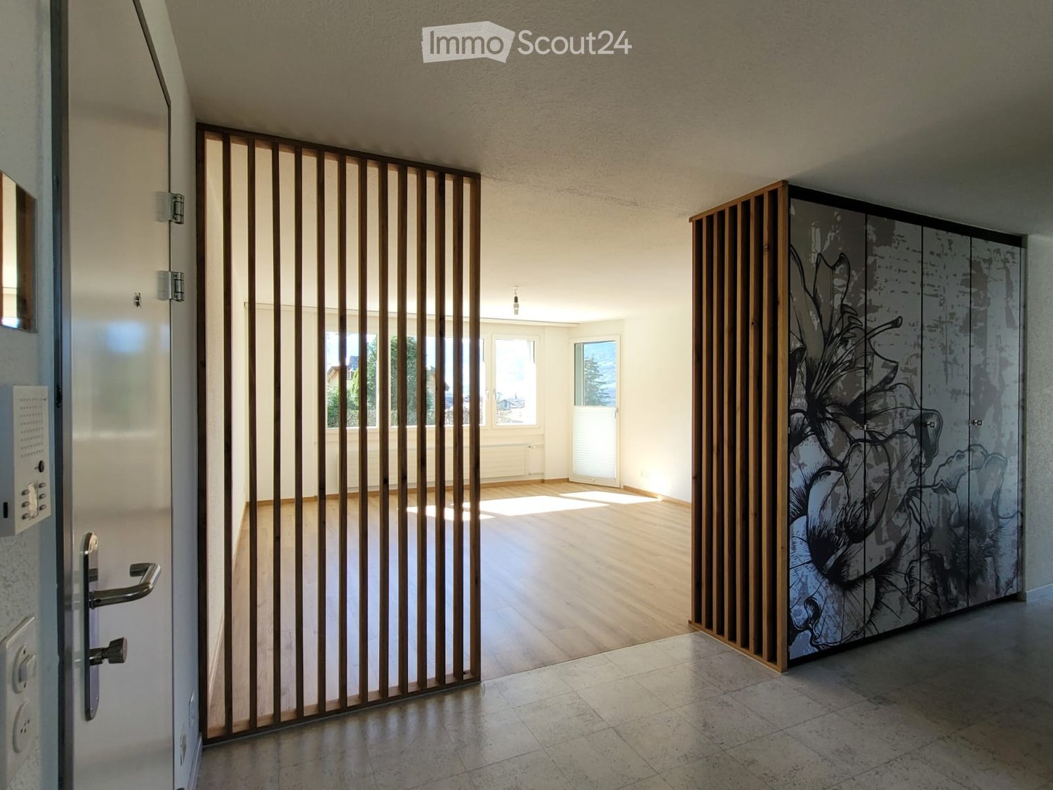 large entryway, wooden flooring, wooden partition, floral-designed cabinet, empty room