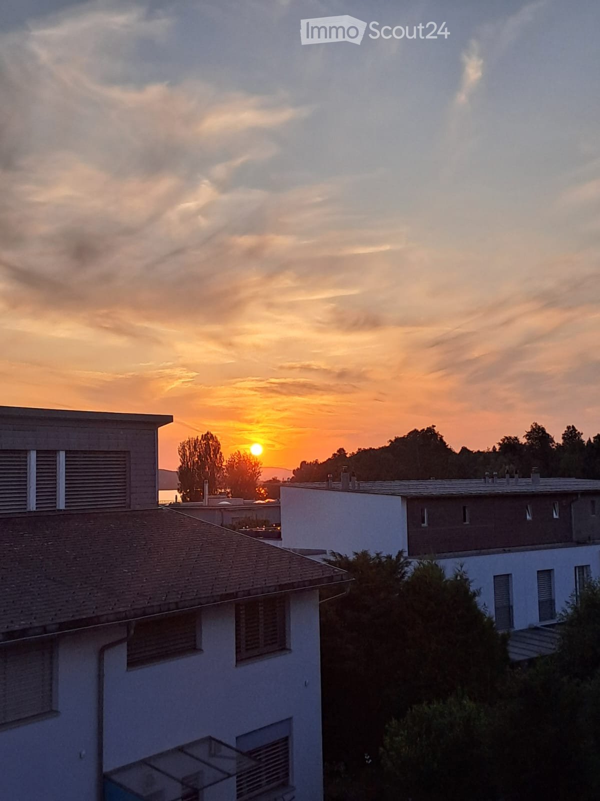 View of two houses with mountains in the distance at sunset