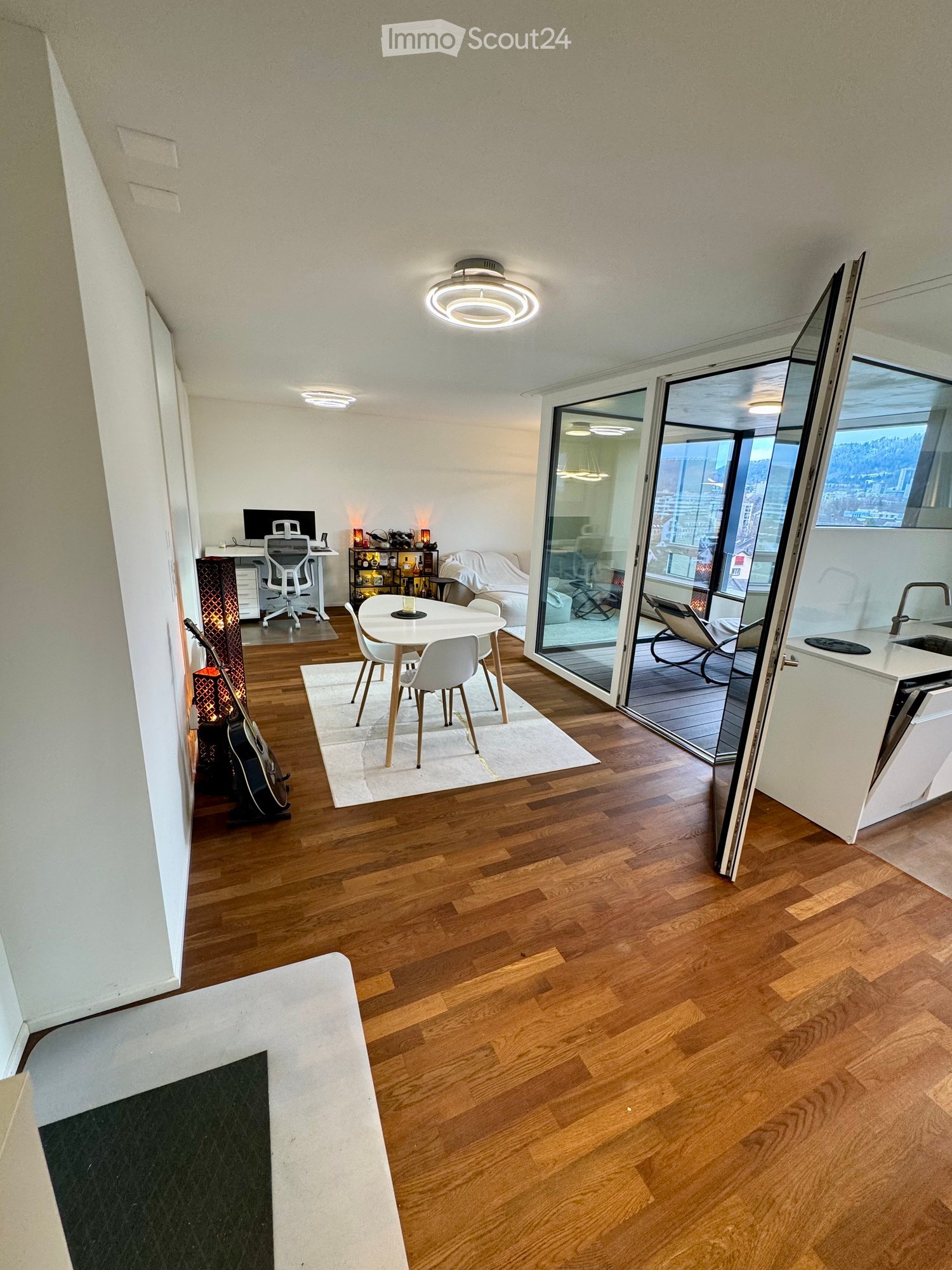 open living room and kitchen with dining table, balcony with outdoor dining table, hardwood floors, modern design