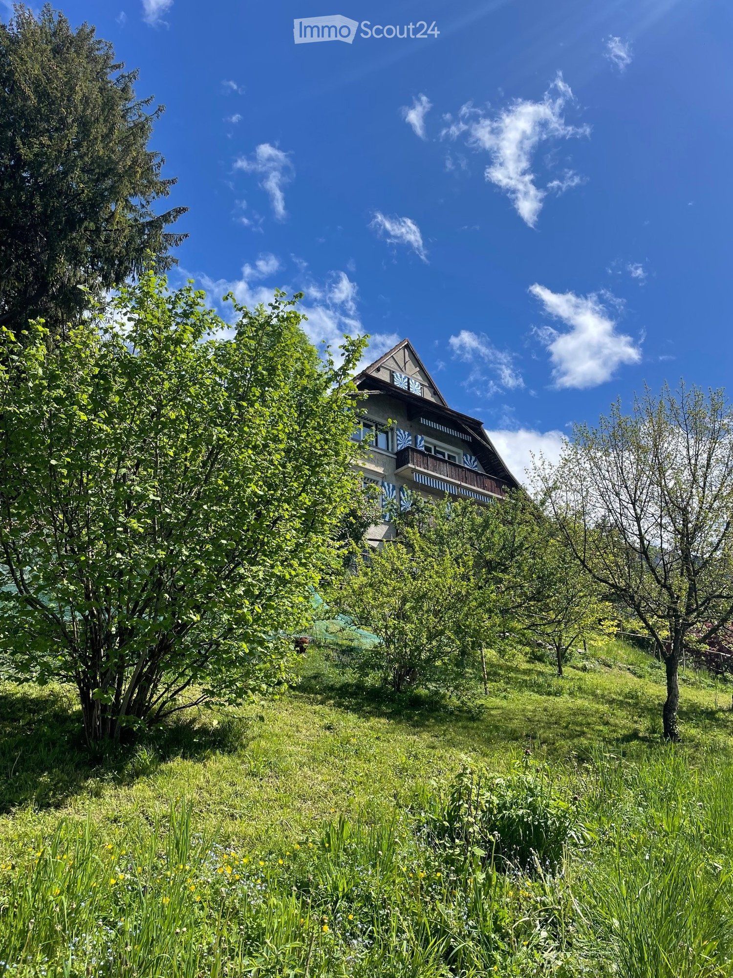 traditional house, 2 story, green landscape, balcony, on hill