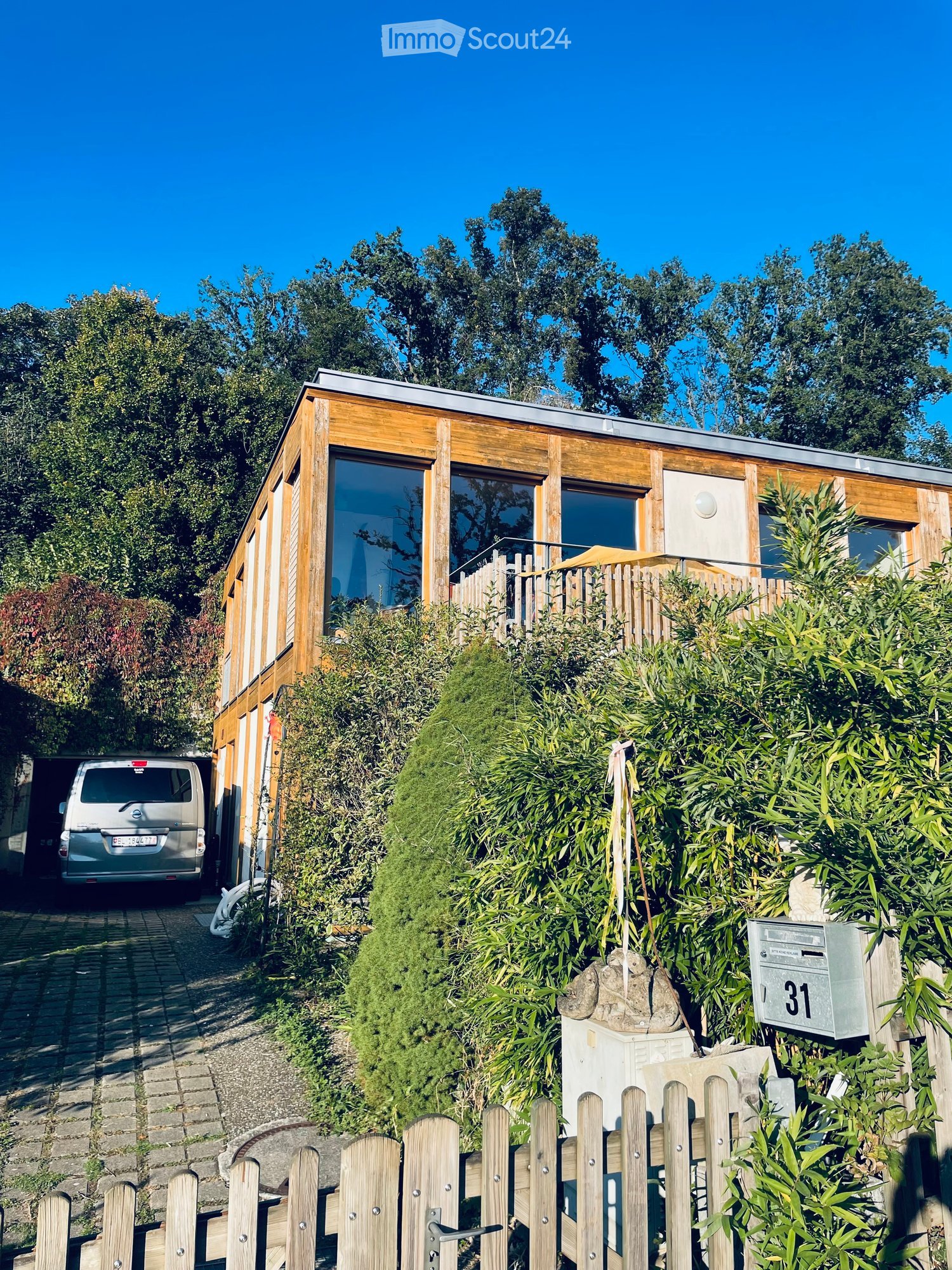 modern wooden house, large windows, wooden entrance, balcony, parked van