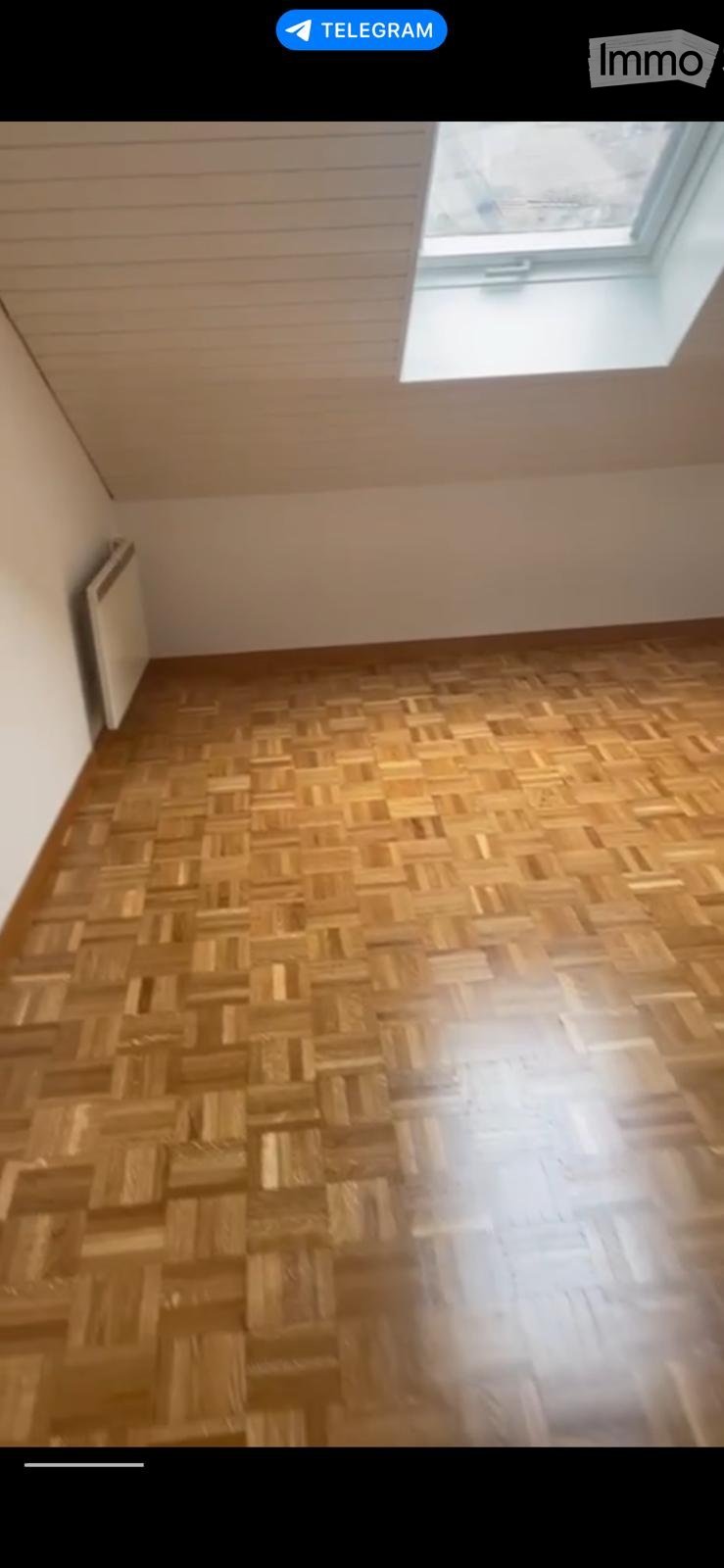 empty room with wooden parquet floor, white wall, wooden ceiling, window in ceiling