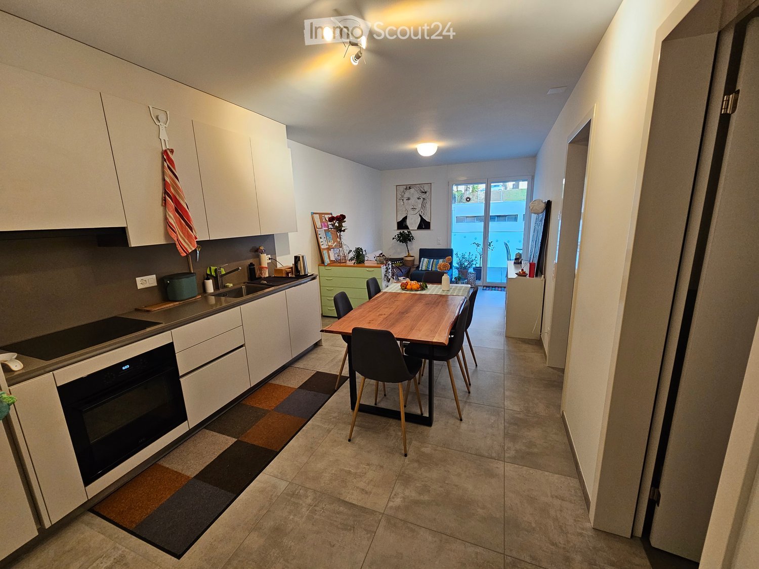 White cabinets, tiled floor, wooden dining table, modern kitchen appliances