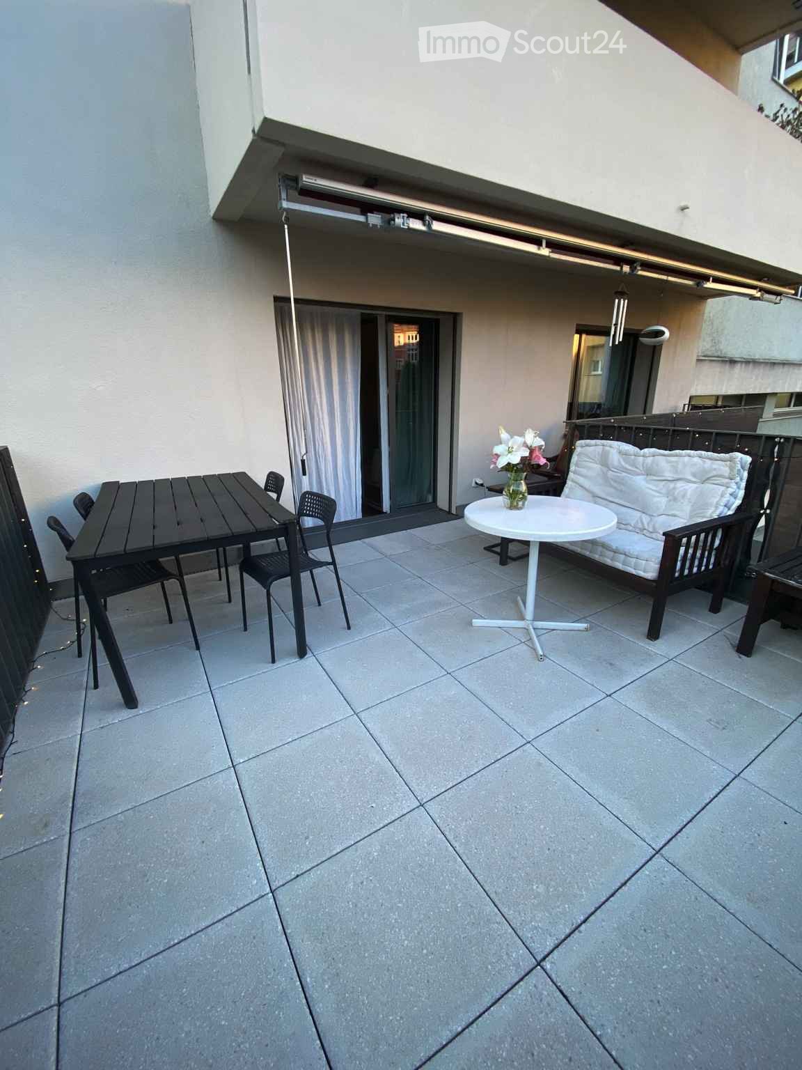 Balcony with table and chairs, couch, round table with flowers