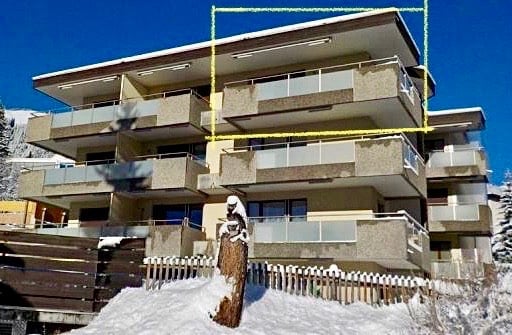 4 story building, balconies on every floor, concrete exterior, fenced area, snow on the ground