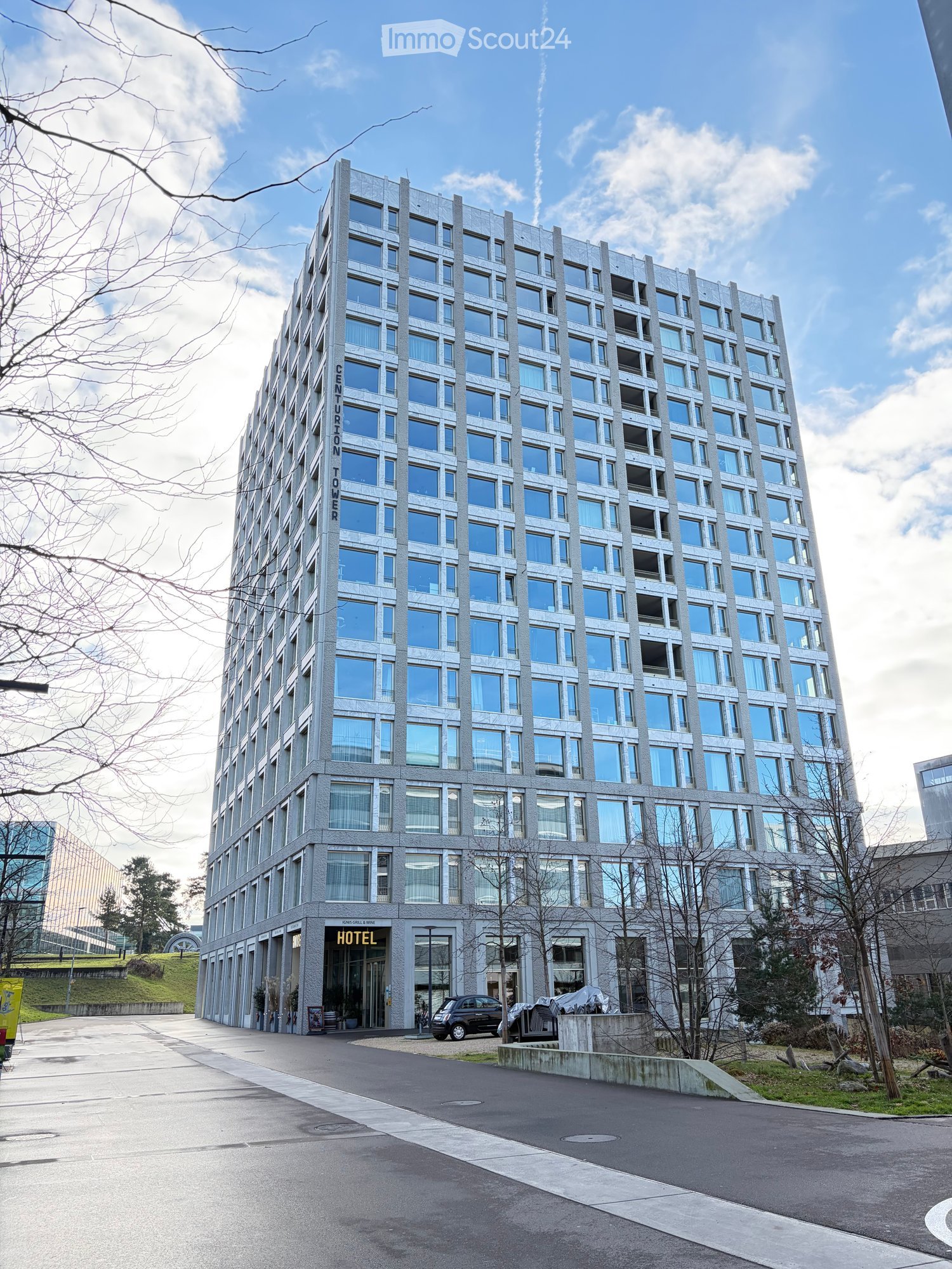 High-rise building, many windows, modern design, office building, concrete exterior, car parked in front