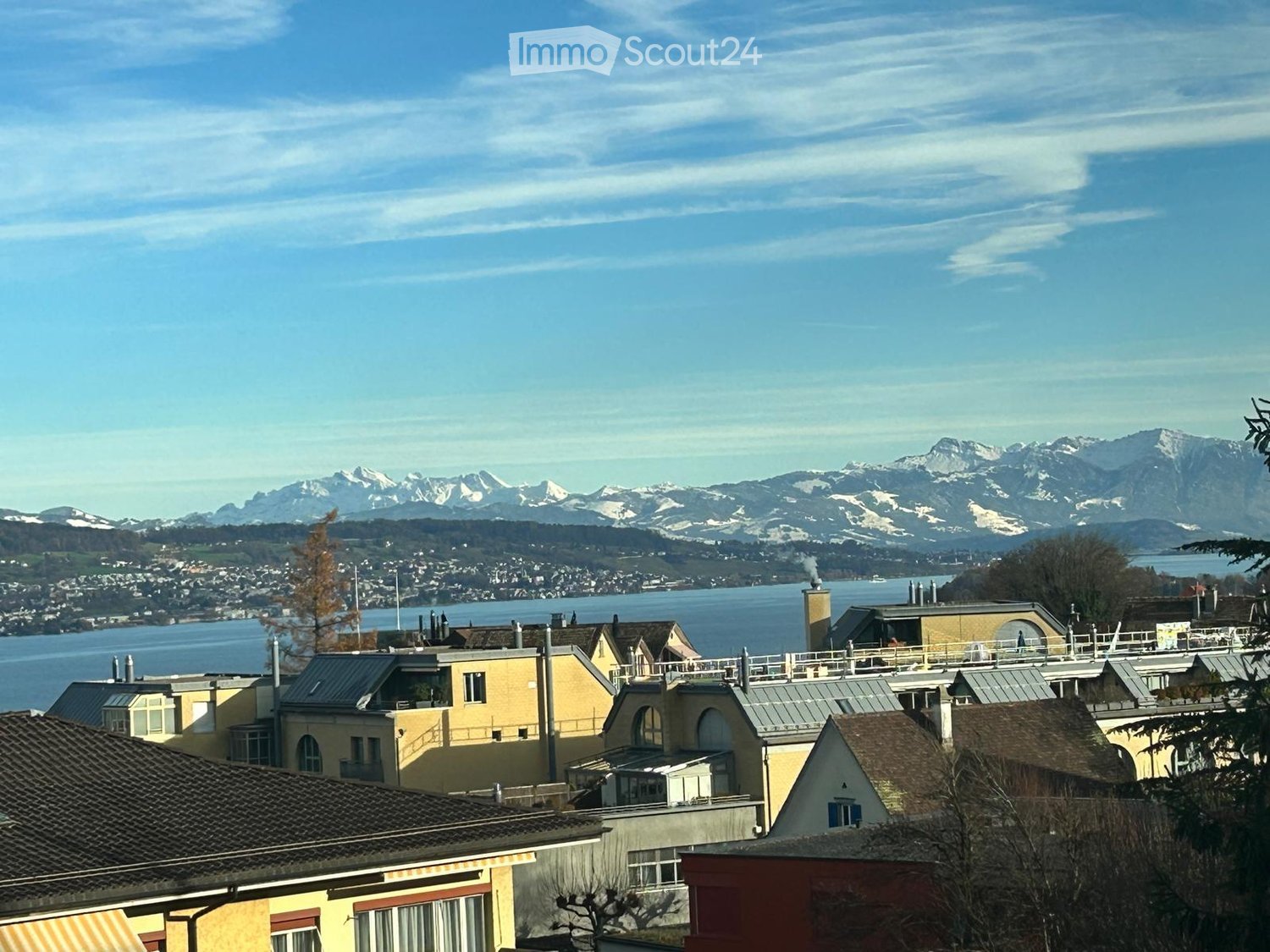 aerial view of a lake with mountains, houses in foreground