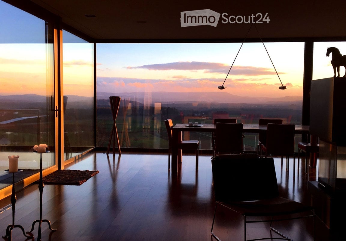dining area with a view to the sunset, wooden floor, floor to ceiling glass walls, chandelier, dining table and chairs, horse statue