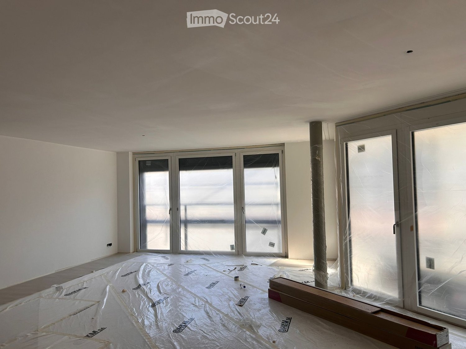 empty room, large windows, glass doors, balcony, covered with protective film