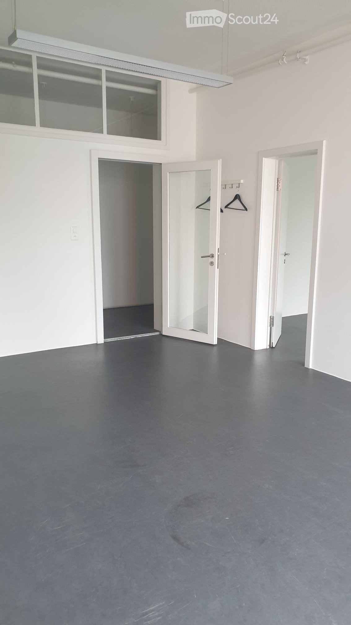 empty room, glass doors, white walls, gray floor, two empty closets