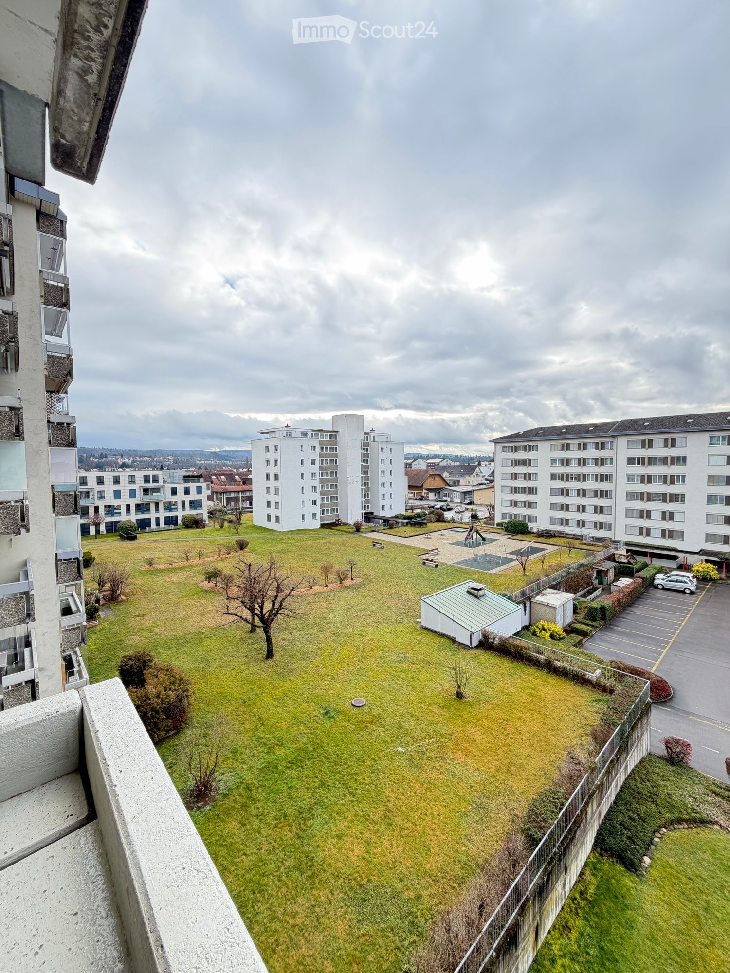 aerial view, green lawn, play equipment, car park, buildings