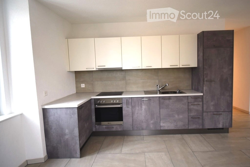 modern kitchen with white and gray cabinets, tiled floor, gas stove, oven, sink, faucet, power outlet