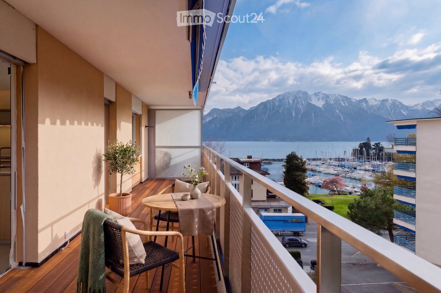 wooden floor, table with chairs, potted plant, railing, view of mountains and lake