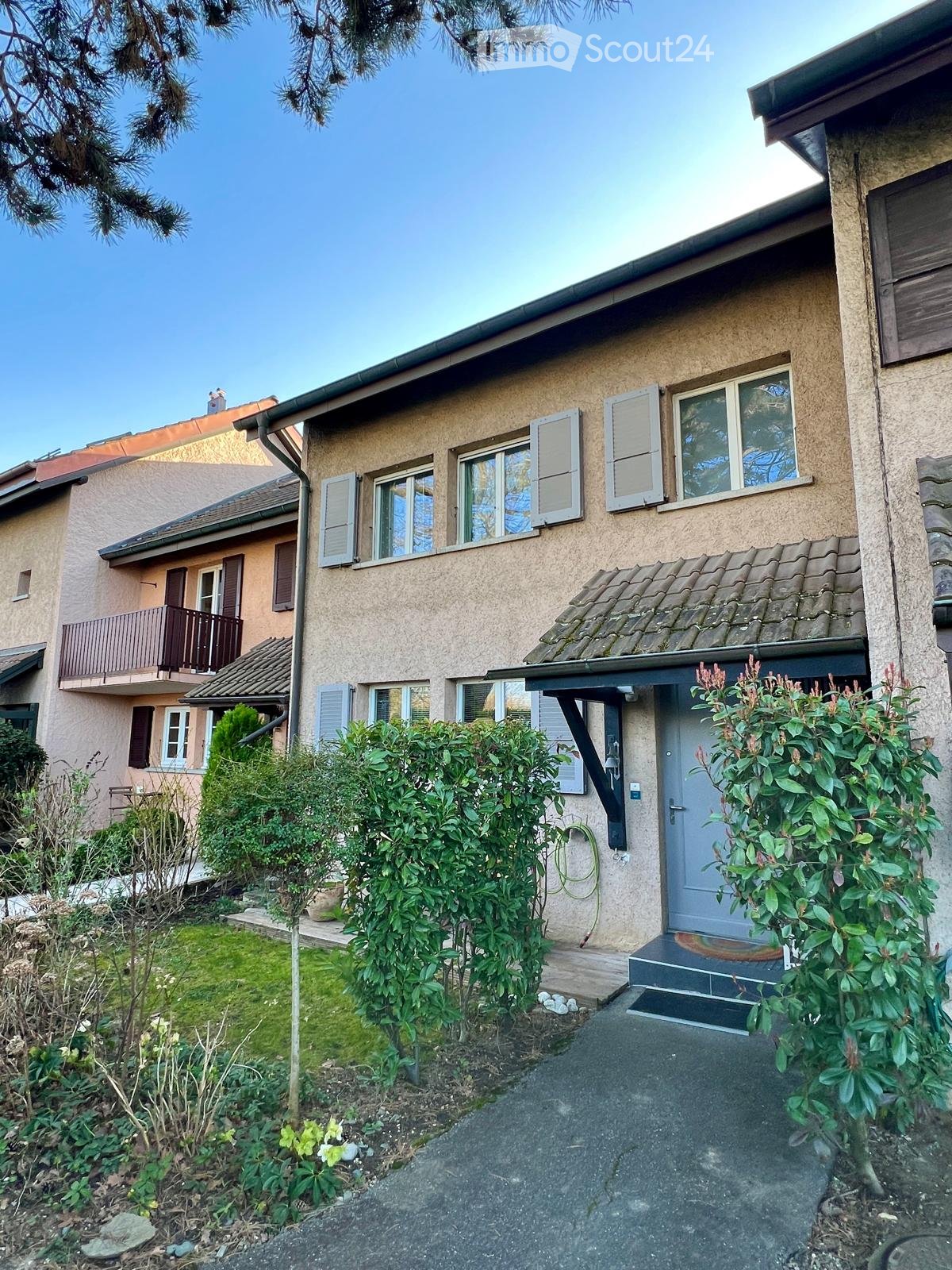 2 story house, beige walls, white windows, brown roof, balcony, driveway, garden