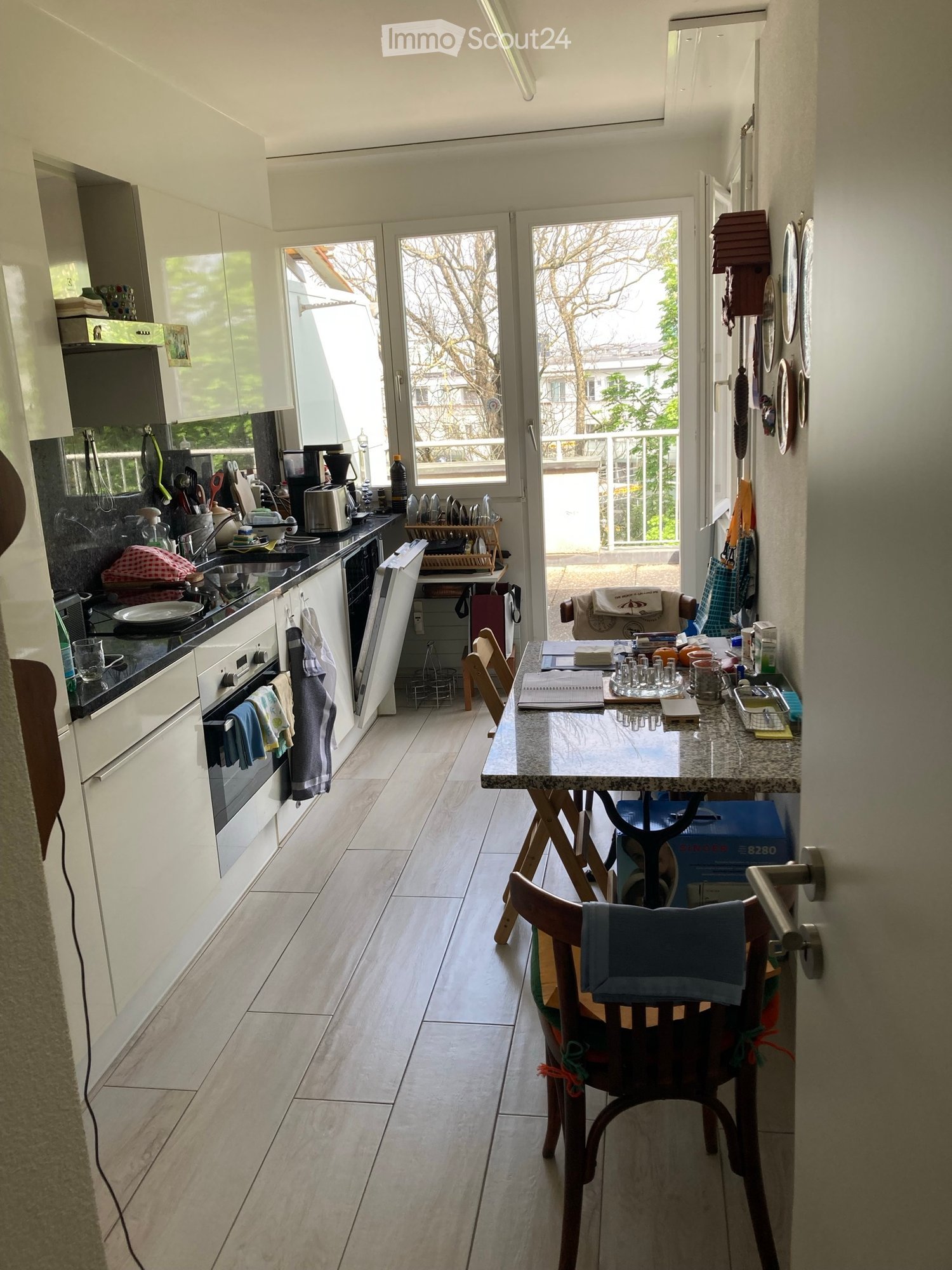 kitchen with dining area, balcony, wooden floor, white cabinets, granite countertop, open to living room
