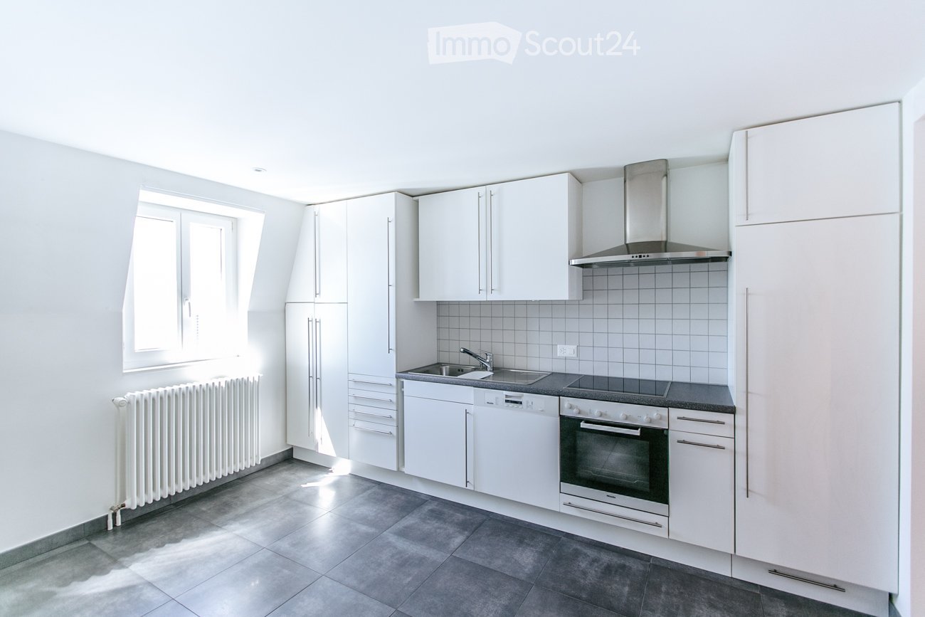 modern kitchen with white cabinets, tiled floor, stainless steel appliances, window, radiator