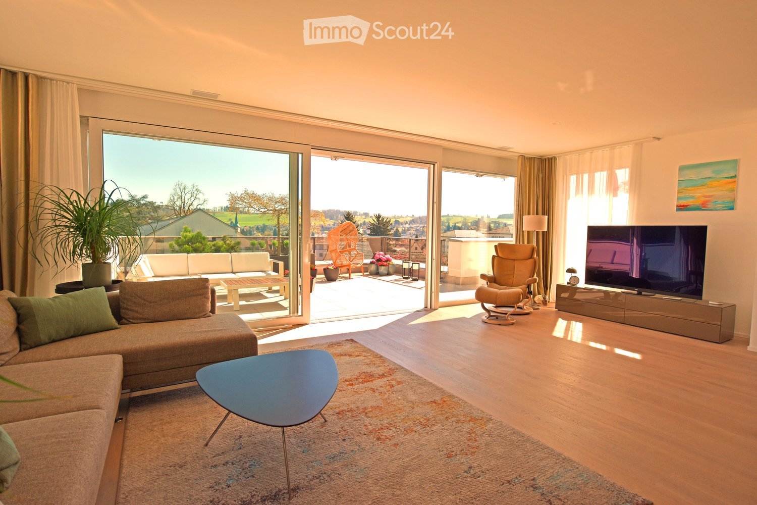 large windows, sliding glass doors, balcony, couch, coffee table, TV, rug