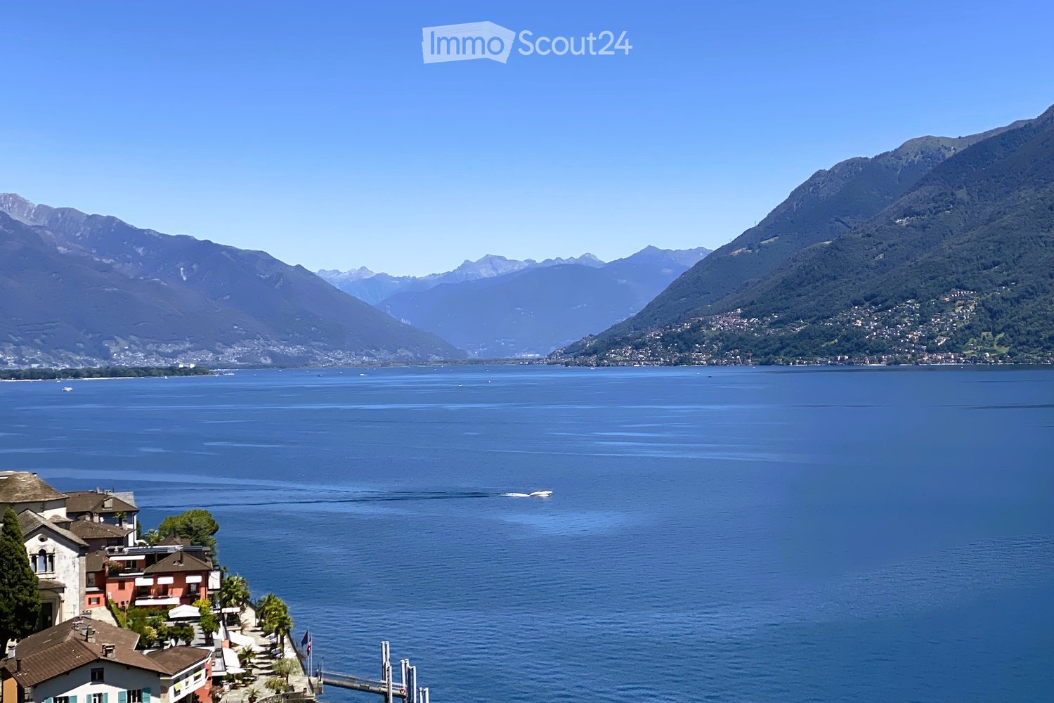 view of the lake, mountains in the background, buildings on the shore