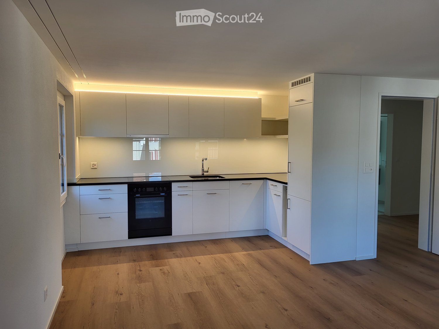 Kitchen. Modern kitchen with white cabinets, black countertop, and wooden flooring.