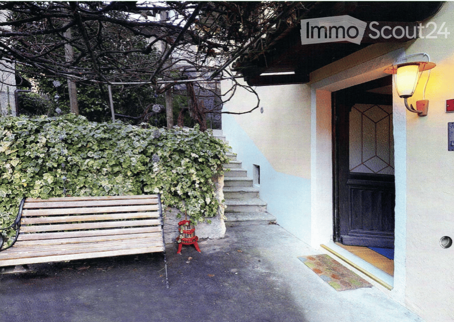 Garden / Outdoor Area. A raised entrance pathway leads to a building with a wooden bench and a small flower pot nearby.