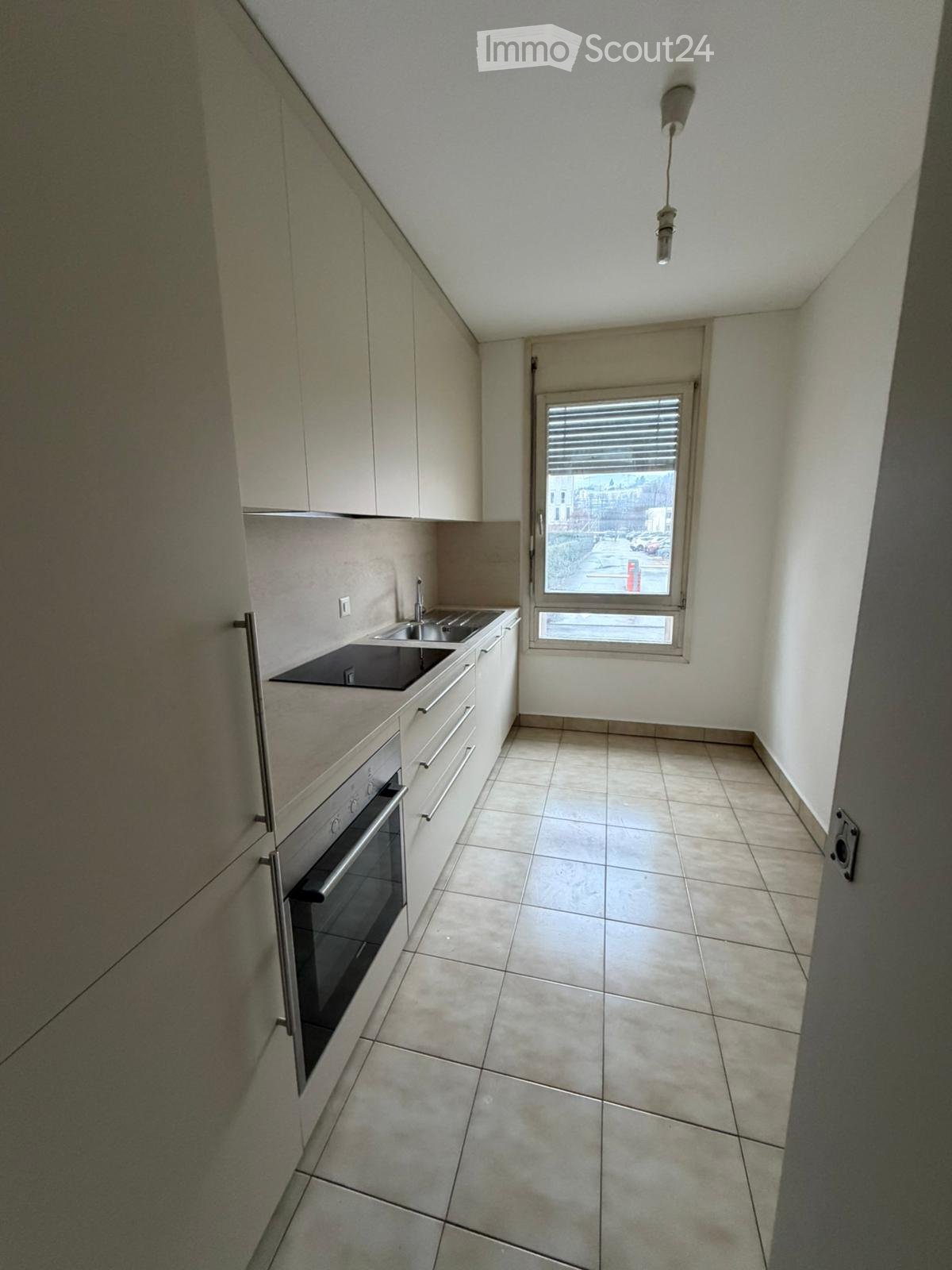 empty kitchen, white cabinetry, black counter, double sink, oven