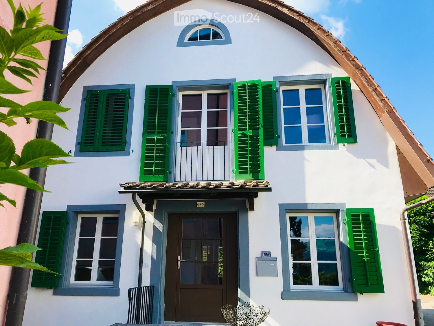 2 story house, white walls, green shutters, brown roof, 4 windows, brown door, chimney