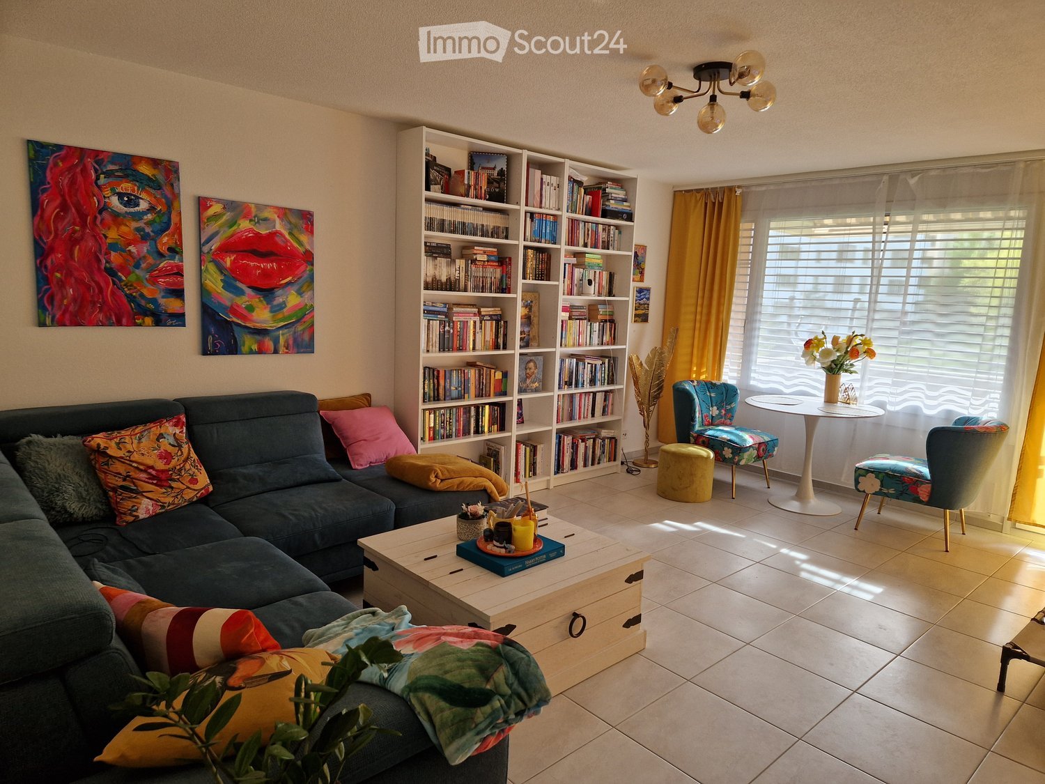 Living room with a couch, coffee table, bookshelves, and a window with a view