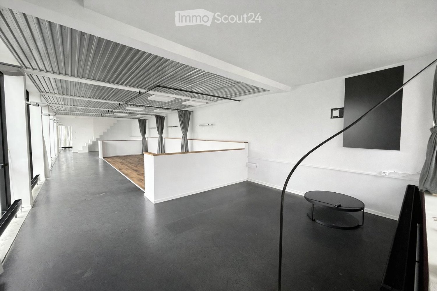 Empty room, black floor, white walls, wooden floor, black table, metal railing, black curtains