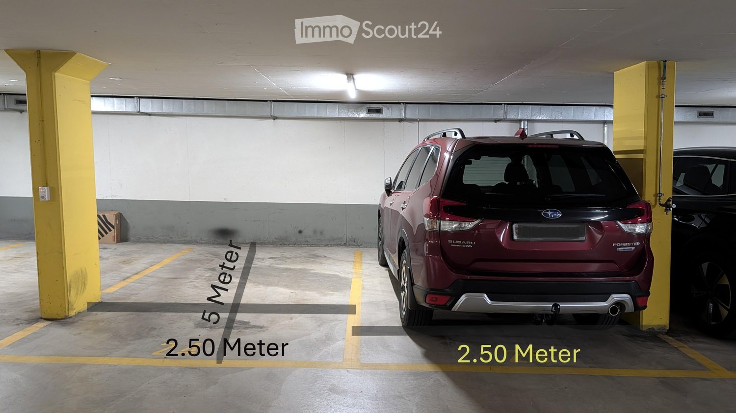 Underground parking area with a red Subaru Forester SUV parked in a designated spot, marked dimensions of 5 meters by 2.50 meters, and yellow support pillars.