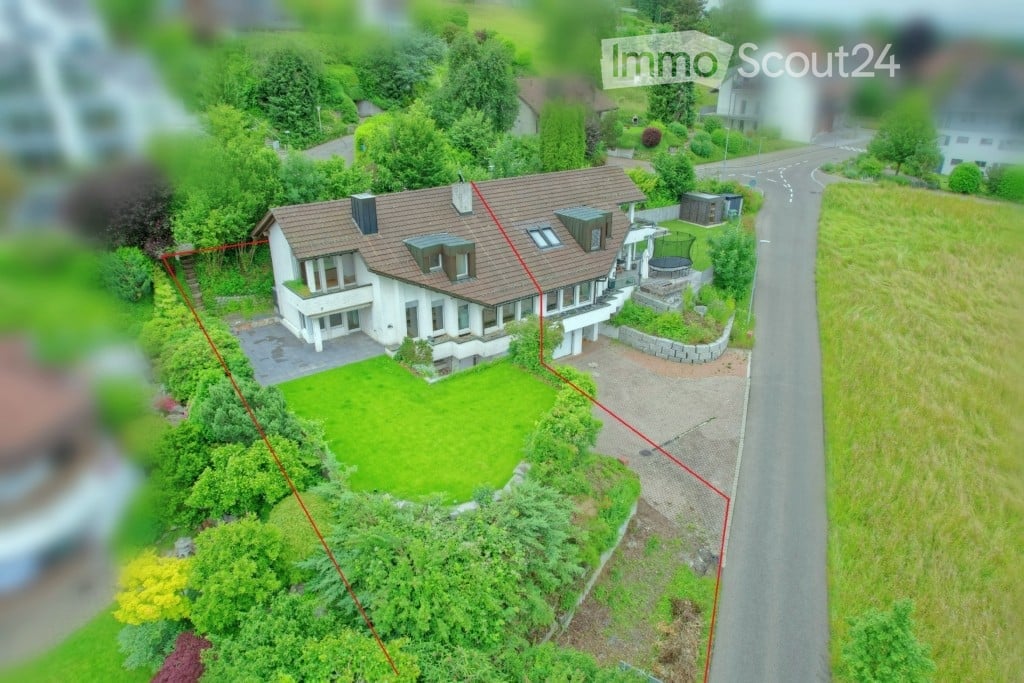 Detached house, brown roof, white walls, driveway, garden, green lawn, trees, bushes, road