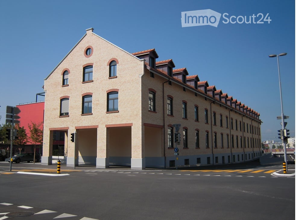 3 story building, brick walls, multiple windows, garage entrance, street lights